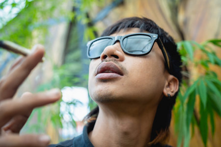 Young man smoking cigarettes with medical marijuana