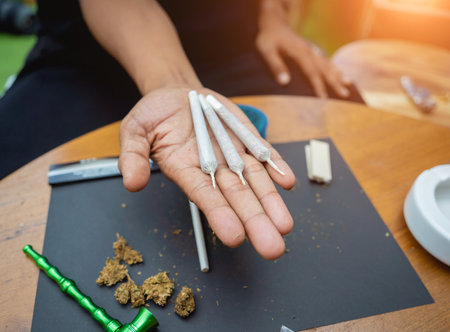 Young man making cigarettes with medical marijuanaの写真素材