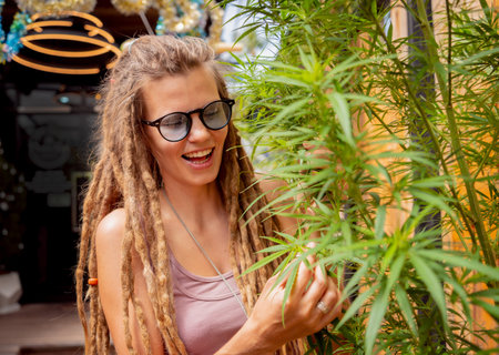 Hippie style woman growing medical marijuana bushの写真素材