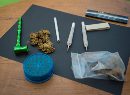 Joints and buds of medical cannabis and cigarettes on a wooden tableの写真素材