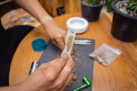 Young man making cigarettes with medical marijuanaの写真素材