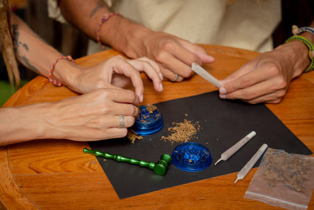 Hippie style couple making medical marijuana cigarettes