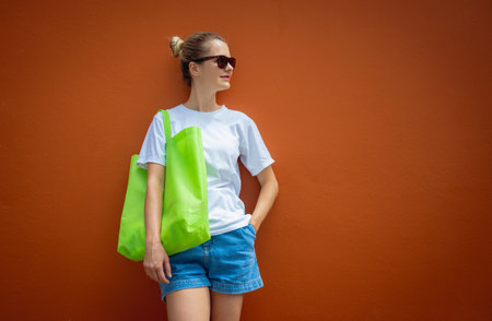 Female model wearing white blank t-shirt on the background of an orange wall.の写真素材