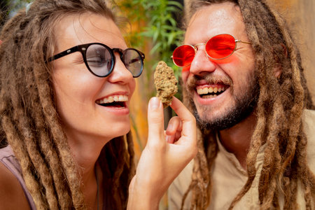 Hippie style couple examines joints and buds of medical marijuana.の写真素材