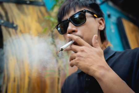 Young man smoking cigarettes with medical marijuanaの写真素材