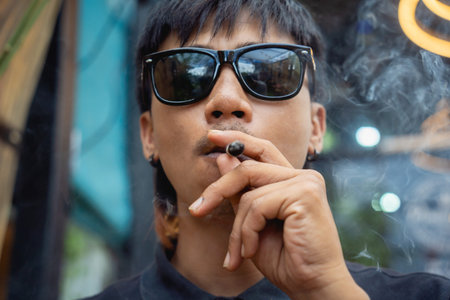 Young man smoking cigarettes with medical marijuana