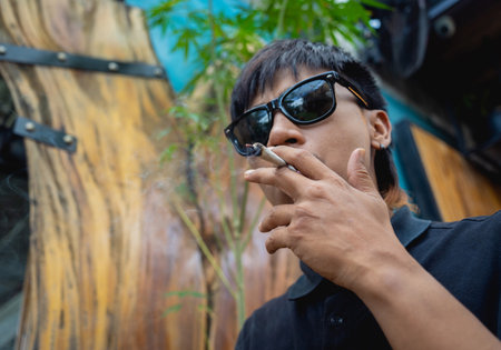 Young man smoking cigarettes with medical marijuanaの写真素材