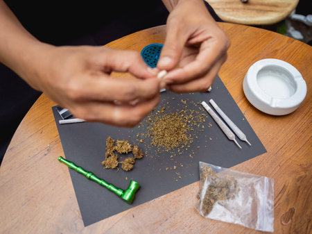 Young man making cigarettes with medical marijuanaの写真素材