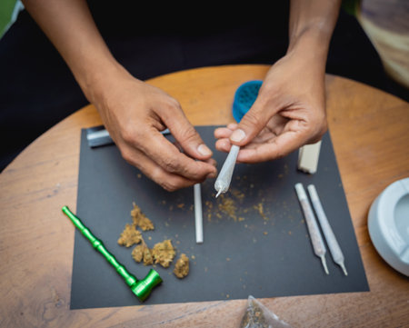 Young man making cigarettes with medical marijuanaの素材 [FY310197317987]