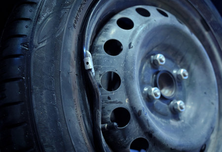 Car with a punctured and broken wheel in a car repair shopの写真素材