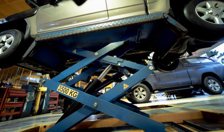 Car on hydraulic lift in auto repair shop