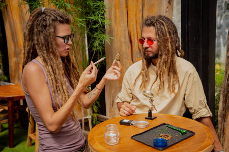 Hippie style couple smoking cigarettes with medical marijuanaの写真素材
