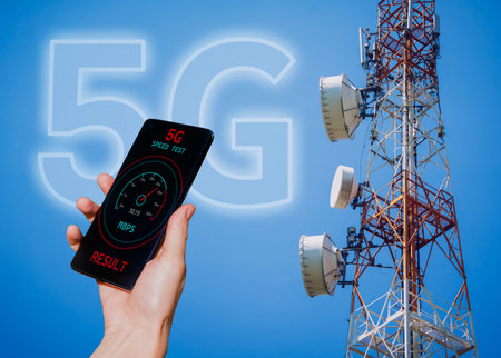 Hands with a phone on the background of 5G cell towers receiving a signalの写真素材