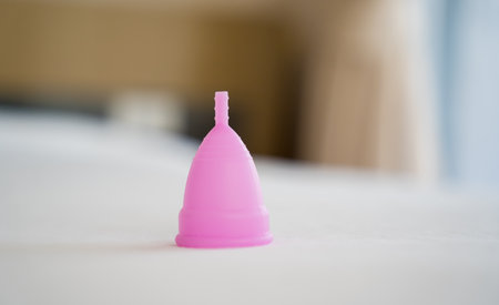 Pink menstrual cup on the bed in the bedroomの写真素材