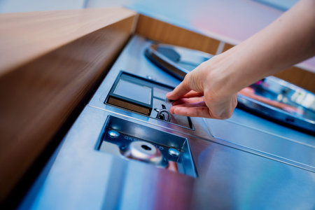 Young woman putting coin in washing machine at laundry