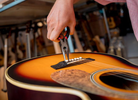 Young musician changing strings on a classical guitar in a guitar shopの写真素材
