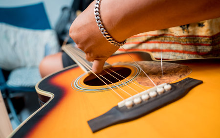 Young musician changing strings on a classical guitar in a guitar shop