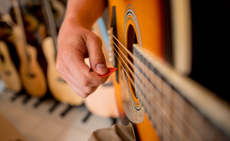 Young musician testing classical guitar in a guitar shop