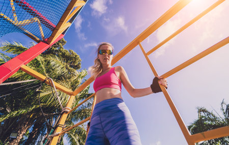 Athletic young woman working out at the rope training camp.