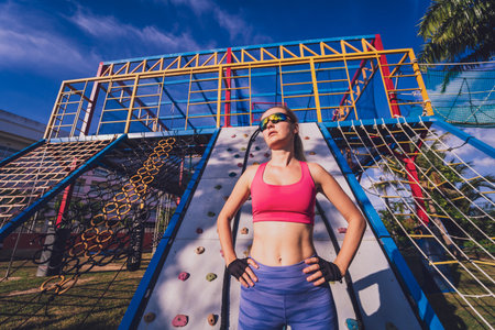 Athletic young woman working out and climbing at the artificial rock in training camp.の写真素材