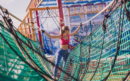 Athletic young woman working out at the rope training camp.の写真素材