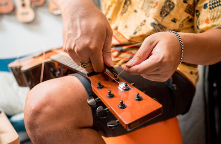 Young musician changing strings on a classical guitar in a guitar shopの写真素材