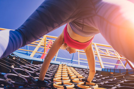 Athletic young woman working out and climbing at the training camp.の写真素材