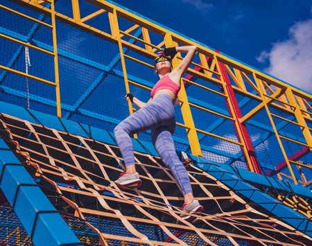 Athletic young woman working out and climbing at the training camp.の写真素材