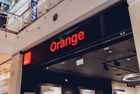 WARSAW. POLAND - MAY 21, 2023: Oarange brand retail shop logo signboard on the storefront in the...