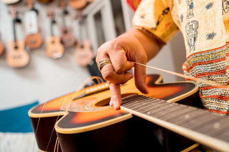 Young musician changing strings on a classical guitar in a guitar shopの写真素材