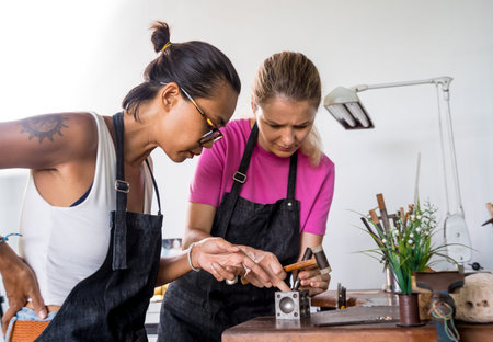 Teacher jeweler and student make jewelry in workshopの写真素材