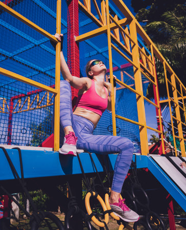 Athletic young woman working out and climbing at the training camp.