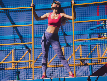 Athletic young woman working out and climbing at the training camp.