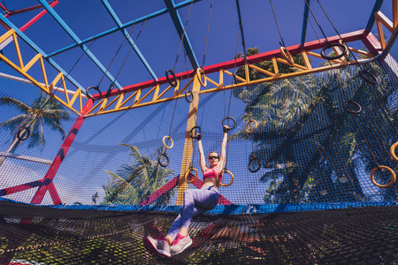 Athletic young woman exercising using gymnastic rings in a training campの写真素材