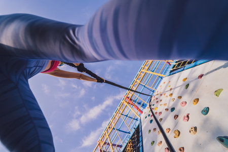 Athletic young woman working out and climbing at the artificial rock in training camp.の写真素材