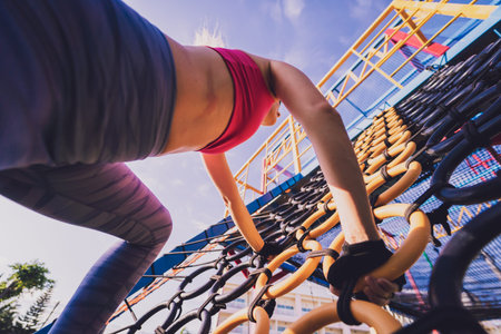 Athletic young woman working out at the rope training camp.