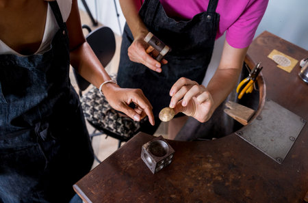 Teacher jeweler and student make jewelry in workshopの写真素材