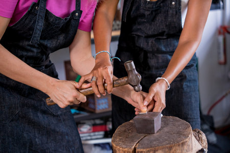 Teacher jeweler and student make jewelry in workshopの写真素材