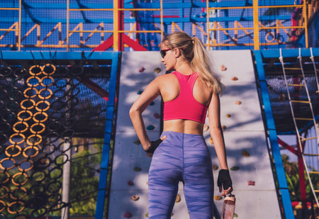Athletic young woman working out and climbing at the artificial rock in training camp.の写真素材