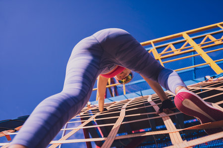 Athletic young woman working out and climbing at the training camp.の写真素材