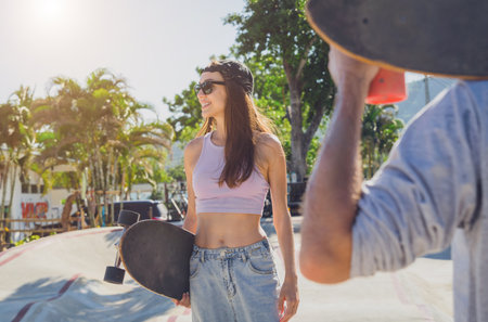 Young happy couple with skateboards enjoy longboarding at the skateparkの写真素材