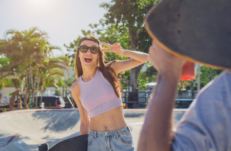 Young happy couple with skateboards enjoy longboarding at the skateparkの写真素材