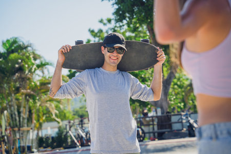 Young happy couple with skateboards enjoy longboarding at the skateparkの写真素材