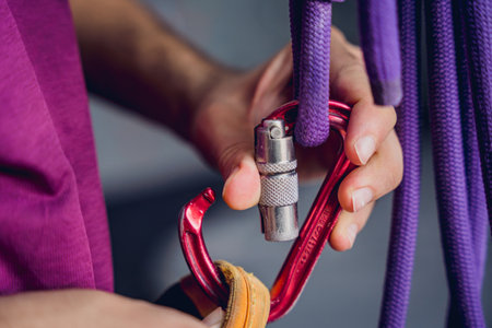 A strong male climber climbs an artificial wall with colorful grips and ropes.の写真素材