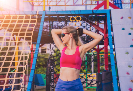 Athletic young woman working out and climbing at the artificial rock in training camp.