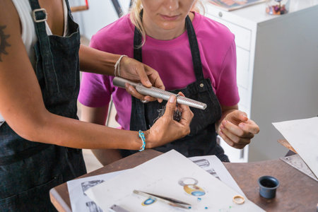 Teacher jeweler and student make jewelry in workshop