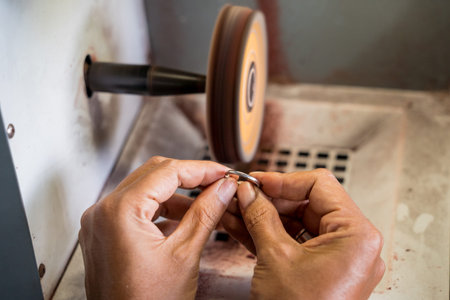 Teacher jeweler and student polishing jewelry in workshopの写真素材