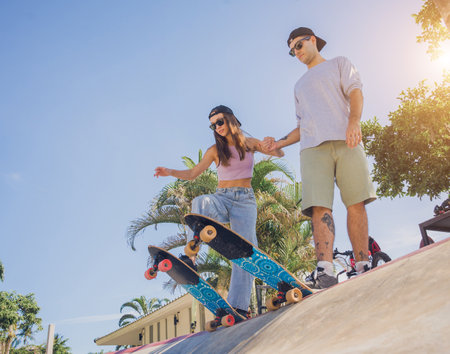 Young happy couple with skateboards enjoy longboarding at the skateparkの写真素材