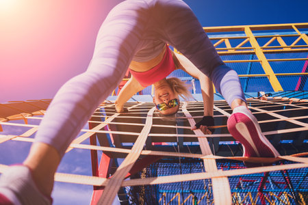 Athletic young woman working out and climbing at the training camp.の写真素材