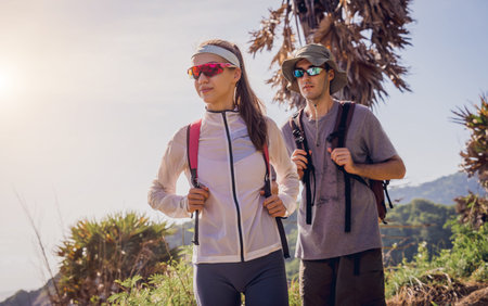 Happy young couple climbs to the top in the mountains near the ocean